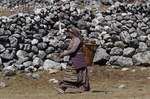 Donna di etnia Sherpa mentre raccoglie sterco di Yak per alimentare il fuoco al villaggio di Na (Foto di Marco Sazzini)