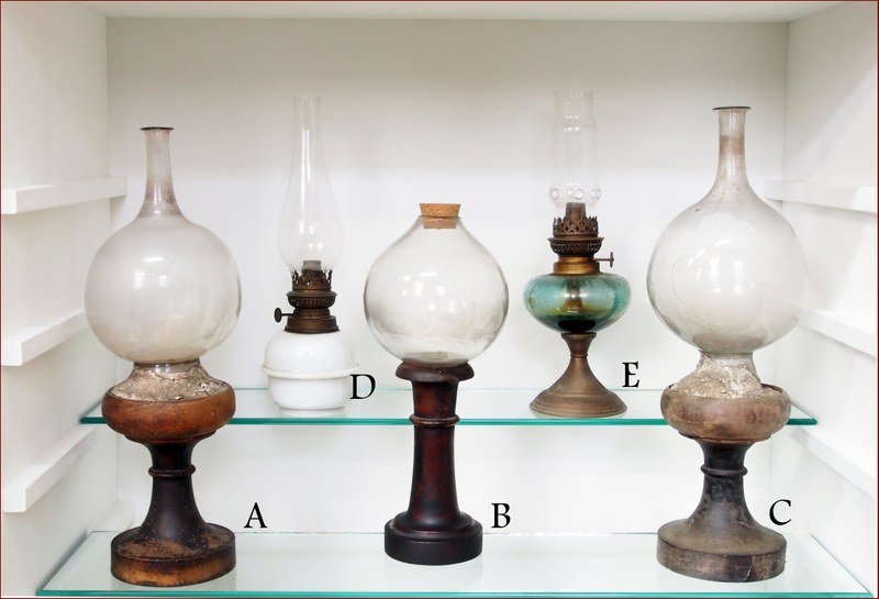 Bolle e lumi a petrolio. Bolle artigianali (A, B, C) e lumi a petrolio (D, E). Le bolle erano impiegate per concentrare la luce sull'oggetto in lavorazione e sono datate alla seconda metà del XIX secolo.