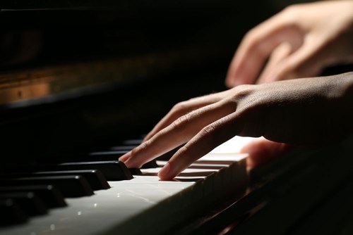 mani che suonano il pianoforte